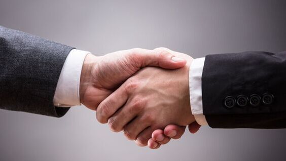 Picture of two business owners shaking hands and agreeing on working together to promote each others skip bin hire businesses.